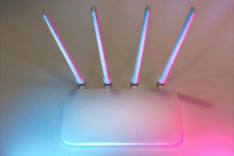 a wifi router in front of blue and pink light