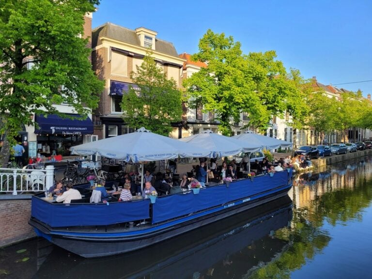 people enjoying lunch in a boat on the canal