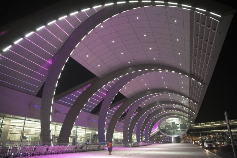 woman walking on the outisde of the dubai international airport terminal