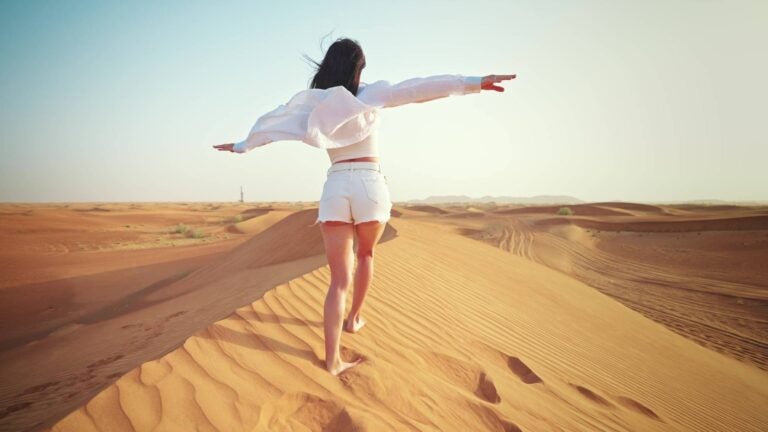 woman walking in the dubai red dunes