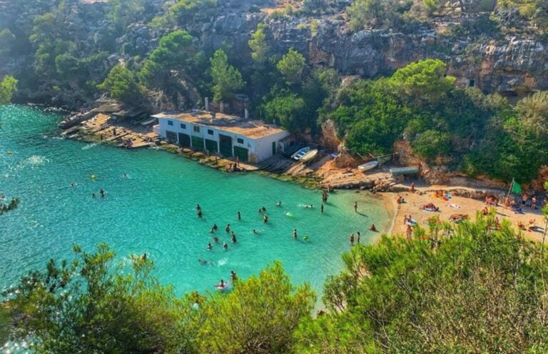 an aerial view of people enjoying beach side fun in a hidden bay in Mallorca 