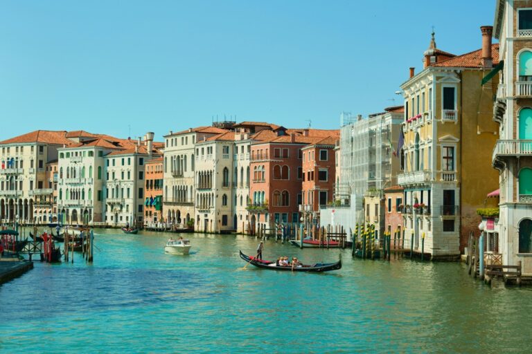 colorful, pastel buildings in venice surrounded by turqouise water in canals 