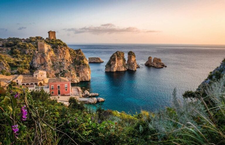 wild foliage and structures on dramatic cliffs overlooking the sea