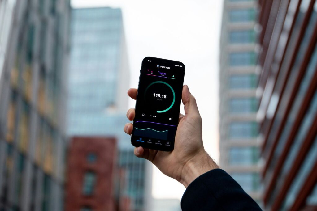 A hand holding up a mobile phone with a speed test on the screen