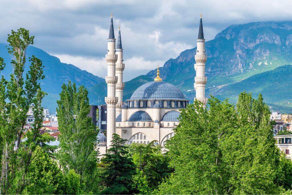 The city of Tirana, Albania and surrounding trees and mountains.