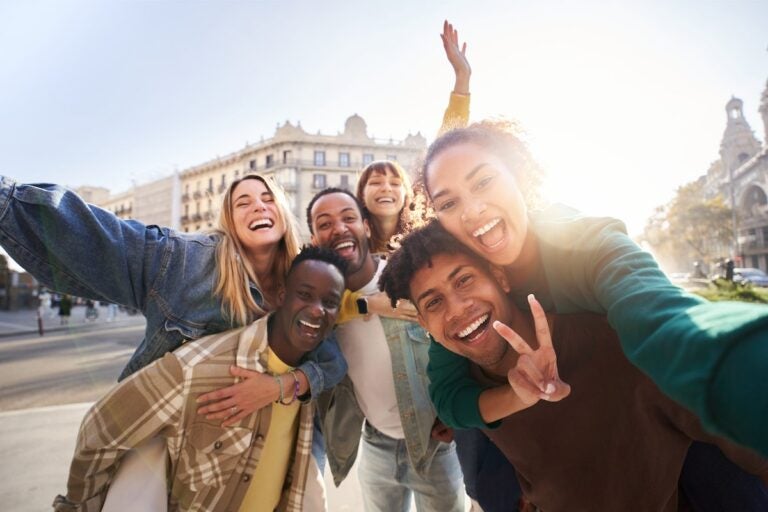 International exchange program students taking a selfie with an European city in the background. 