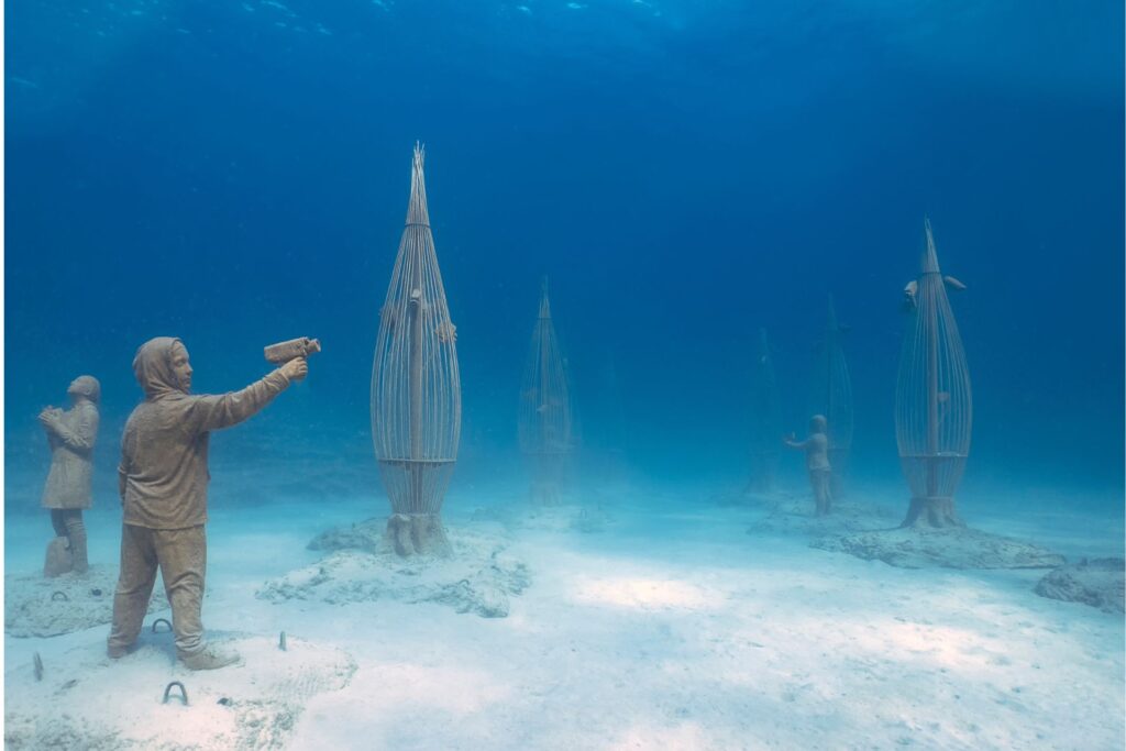 The MUSA (Museo Subacuático de Arte) Museum in Mexico, statues of young people and tear-shaped structures.