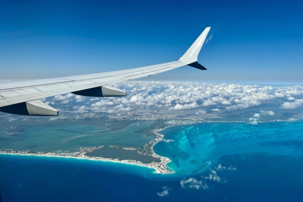 Aerial view of Cancun during the day with the corner of the aeroplane wing on the top left corner.