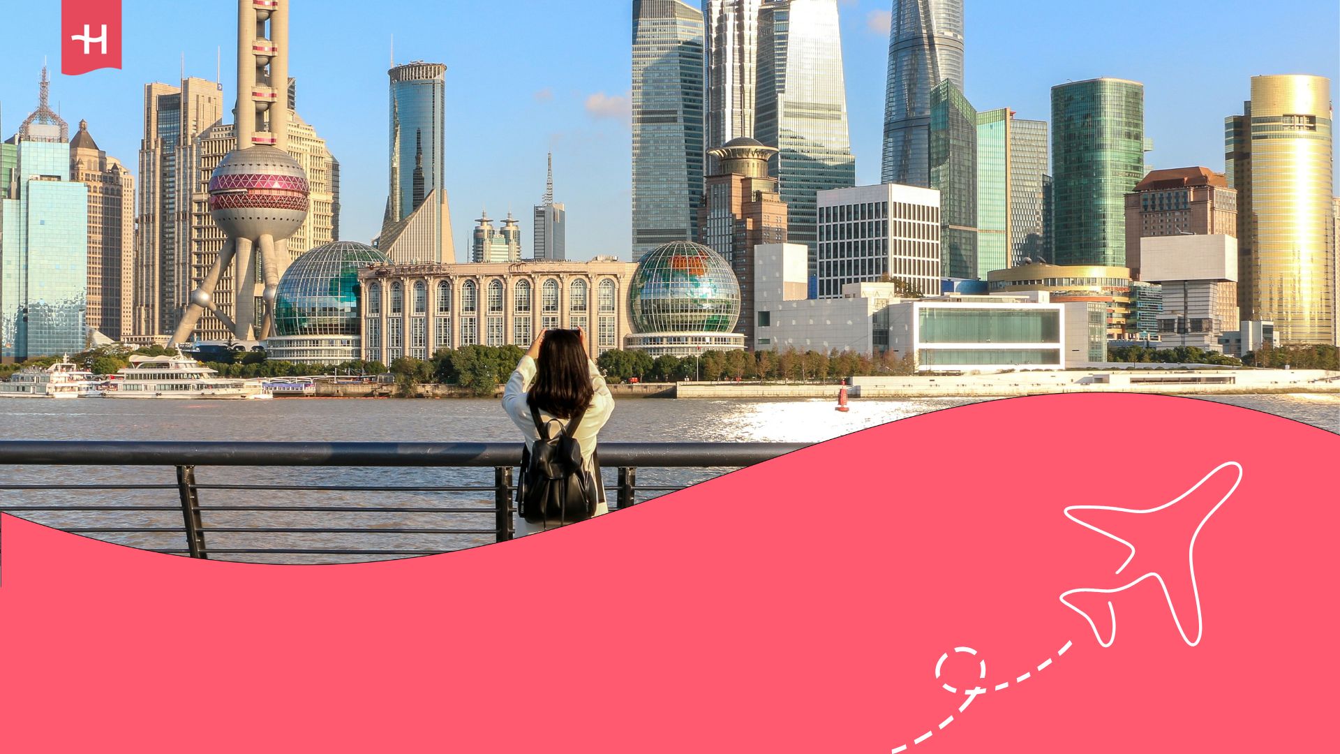 Front view of Shanghai skyline. A woman with a black backpack is taking a photo from the other side of the river. The Holafly logo on the top left corner, and an illustration of an aeroplane is on the bottom right corner.