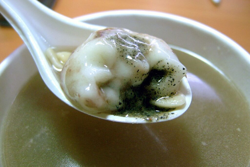Close-up of a sweet rice ball dish in a clear-like broth.
