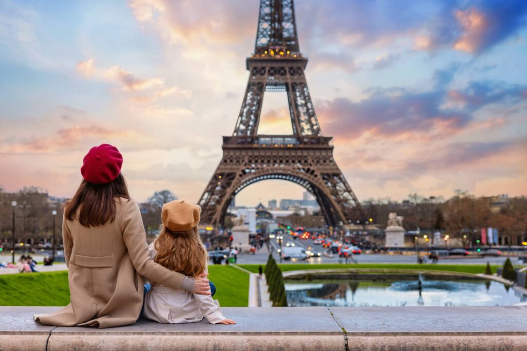 Woman with her children sitting in front of the eiffel tower