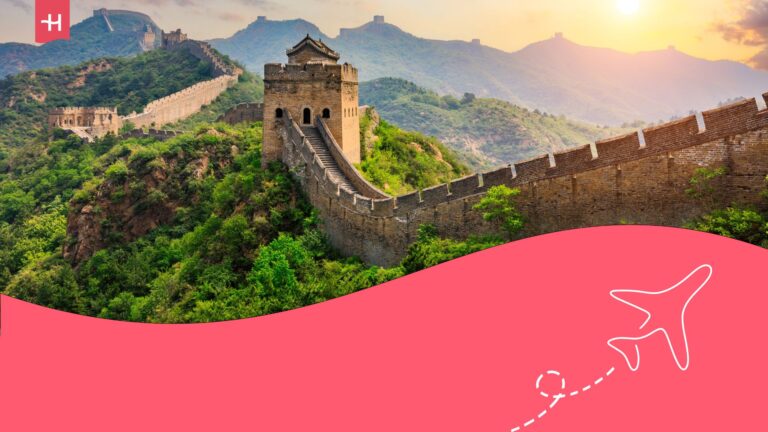 Great Wall of China at dusk. Holafly logo on the top left corner, and an illustration of an aeroplane on the bottom right corner.