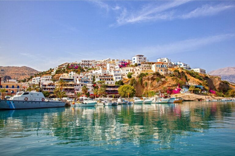 View of Crete from the water, with boats docked at the port.