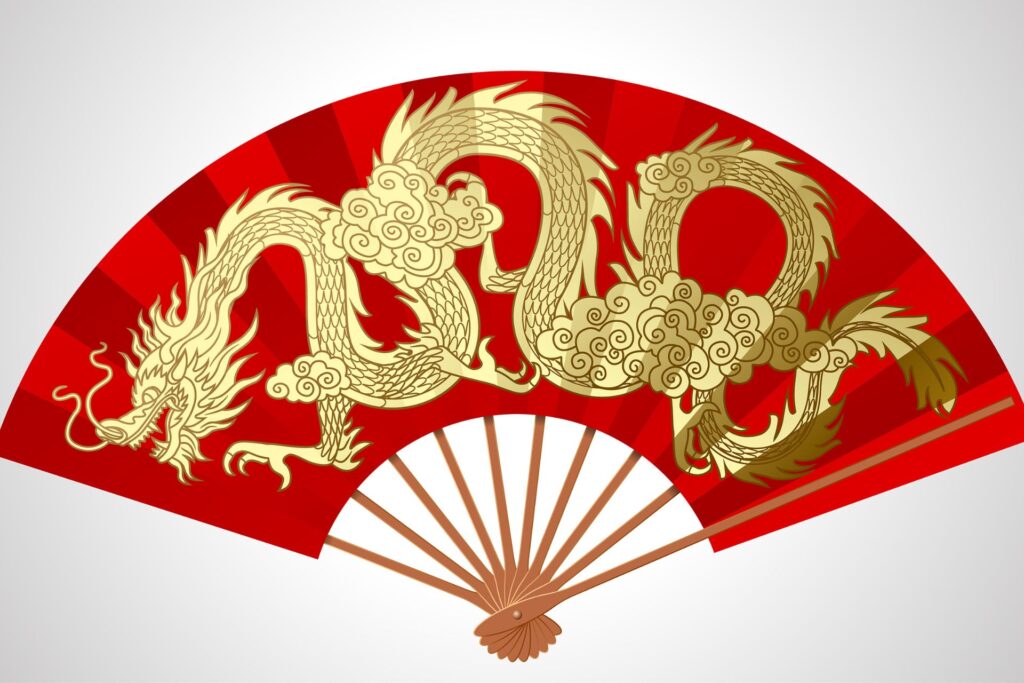 Red fan with wooden stem and a gold dragon painted on the front.