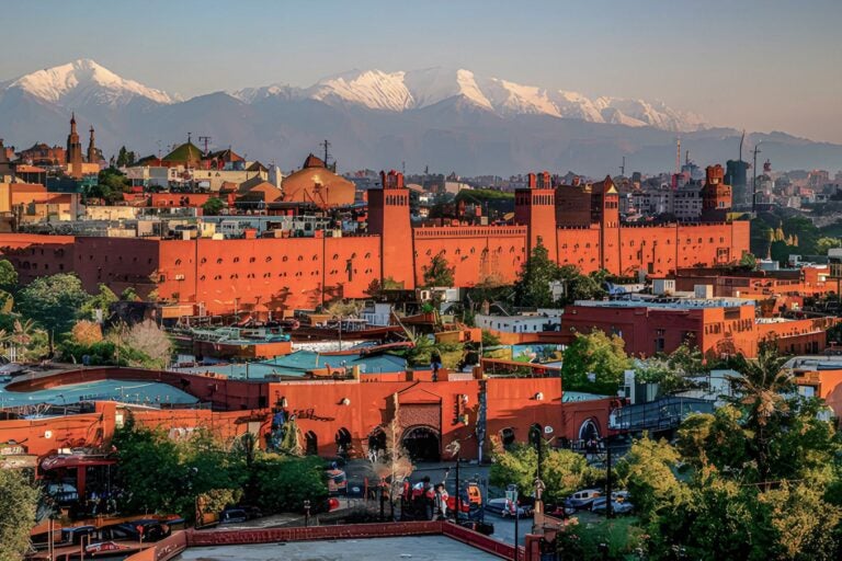 The city of Marrakech from above with mountains in the background.