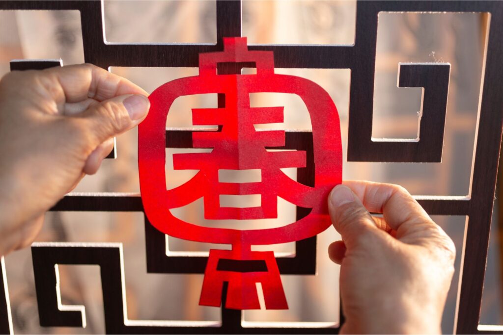 Red Chinese paper cutout against a larger black design/cutout.