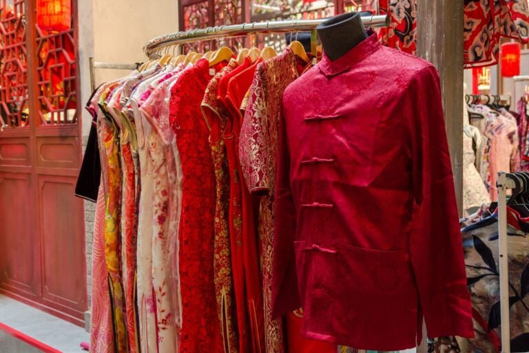 Rack of red traditional Chinese dresses and garments.