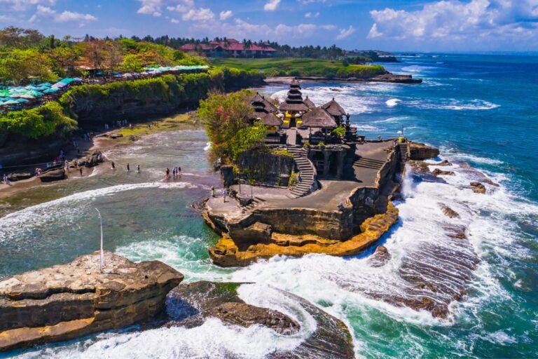 Aerial view of the island of Bali and one of its seaside temples.