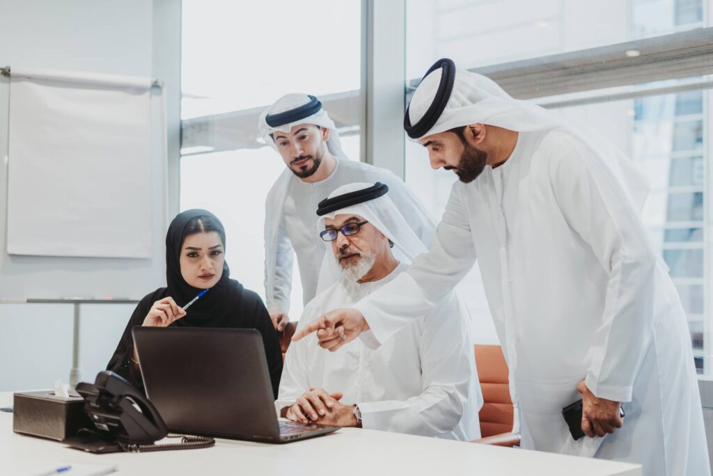 People in Dubai pointing at a laptop