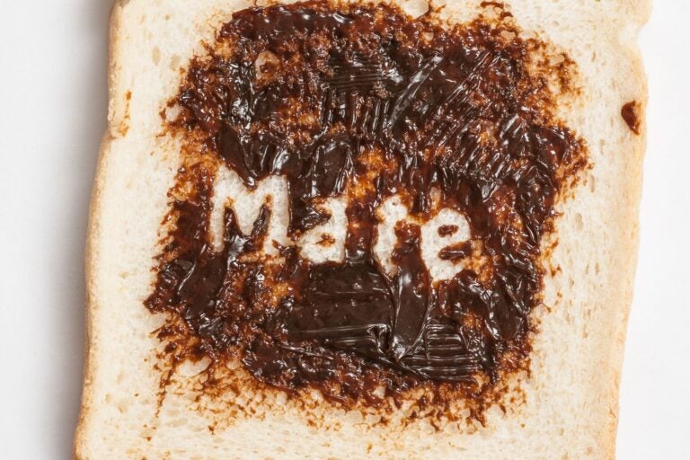 A piece of white bread with Vegemite on it, and the word "mate" scratched in the middle.