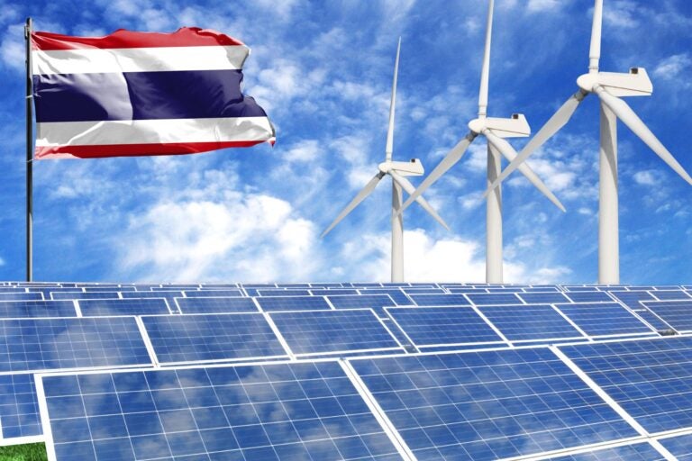 Solar panels and wind turbines against a blue sky and the Costa Rican flag.