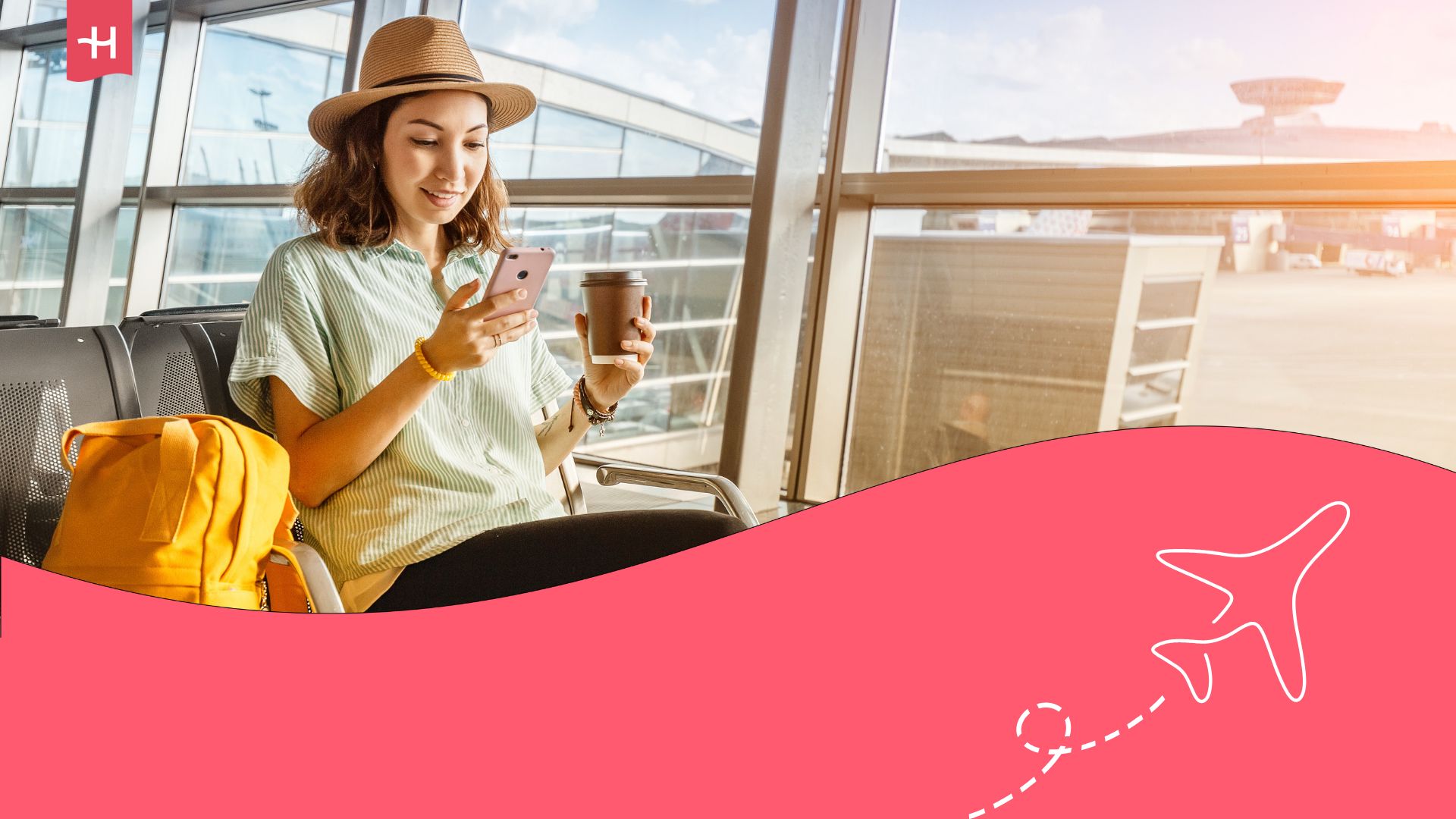 Woman sitting in an airport lounge with a yellow backpack beside her, holding a cell phone in her right hand, and a coffee in her left hand.