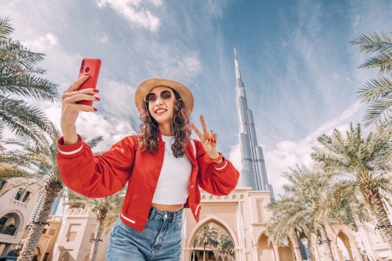 woman using her phone to take a photo with a building in the background