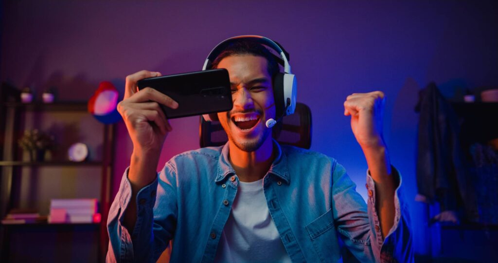 man holding his phone celebrating after winning