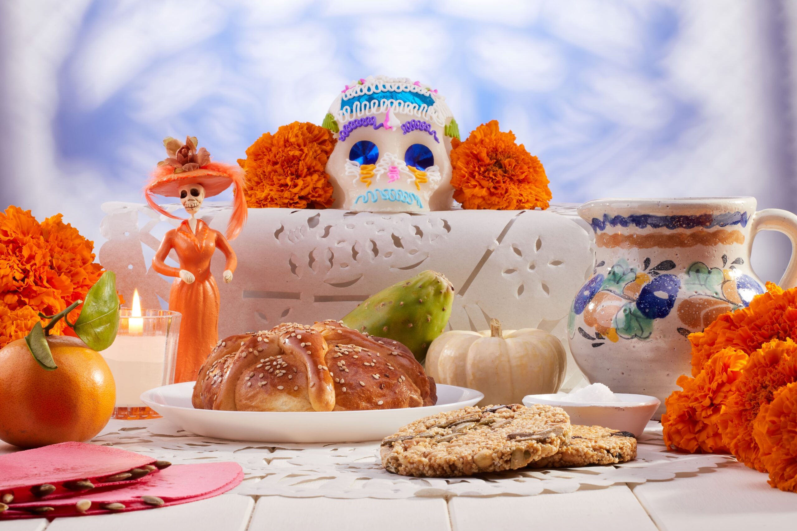 Skeletons and orange flower decorations with food for a Halloween party