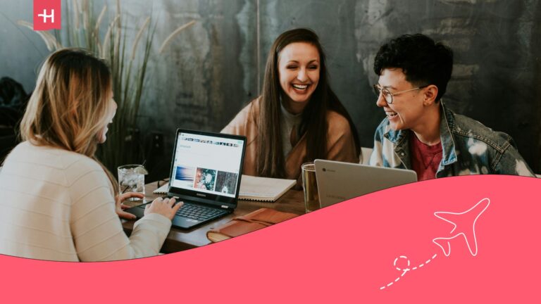 Three students laughing and using collaborative apps for students on a laptop and tablet.