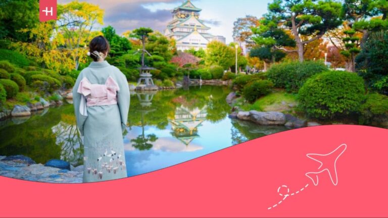 Woman wearing a kimono admiring the view of a castle in Osaka.