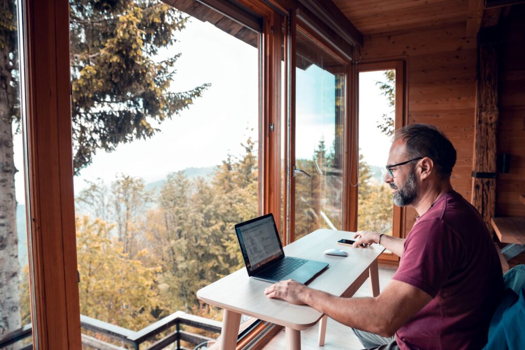 man working remotely from a cabin in the mountains