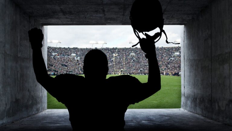 A football player running out of the tunnel onto the pitch
