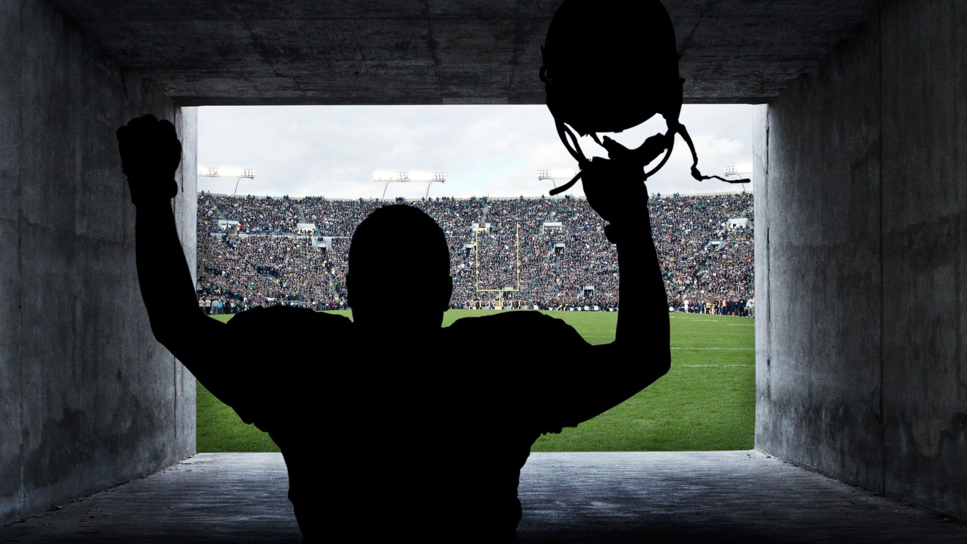 A football player running out of the tunnel onto the pitch