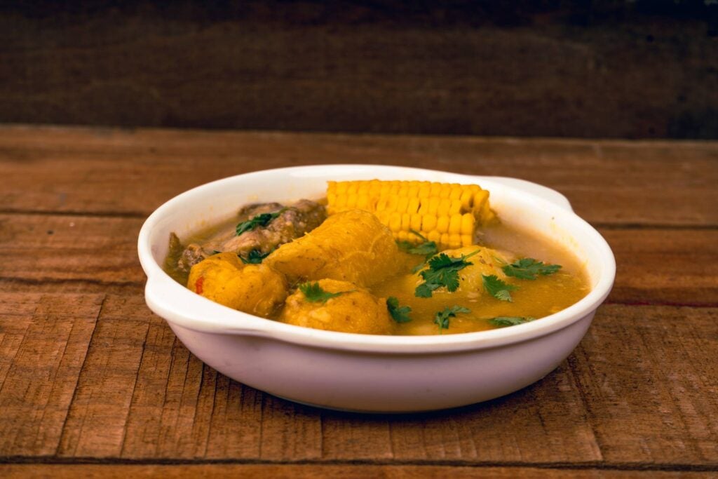 antioquian sancocho served with corn and plantain