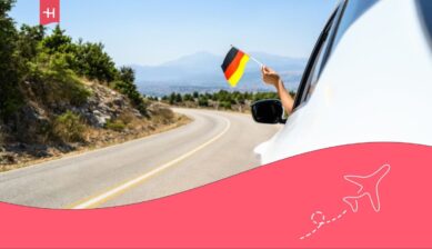 Person driving with a German flag in their hand.