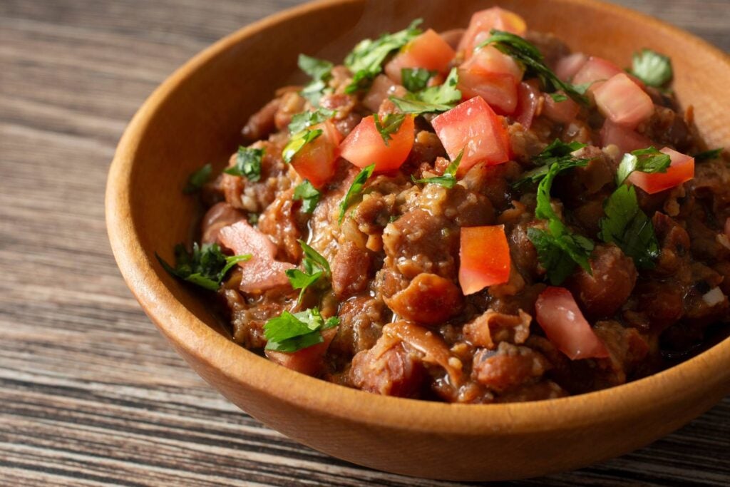 a plate of ful medames with tomate and chopped herbs