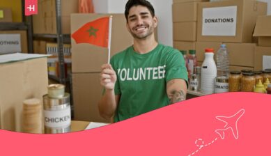 Boy wearing a green volunteer T-shirt and holding a Moroccan flag.