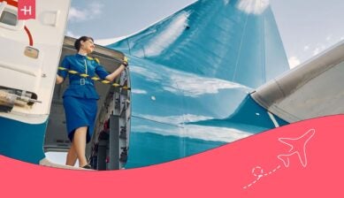 flight attendant standing in the door of an aircraft - guide on how to become a flight attendant
