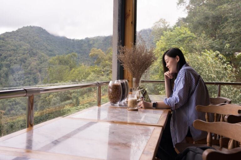 woman working remotely from a cabin in the mountains