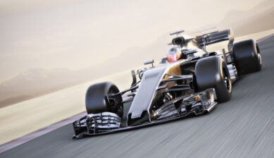Formula 1 car racing at high speed around a track.