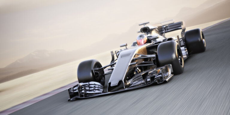 Formula 1 car racing at high speed around a track.