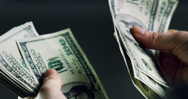 Two hands counting cash in dollar bills.