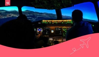 an airplane cockpit lit up in the evening with views of the mountains - best flight schools in canada