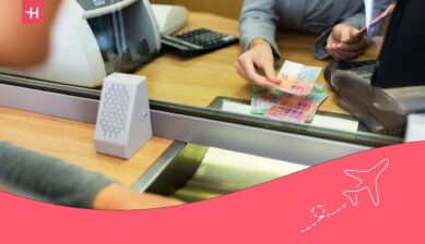 Cashier handing over bills to a client in an international bank.