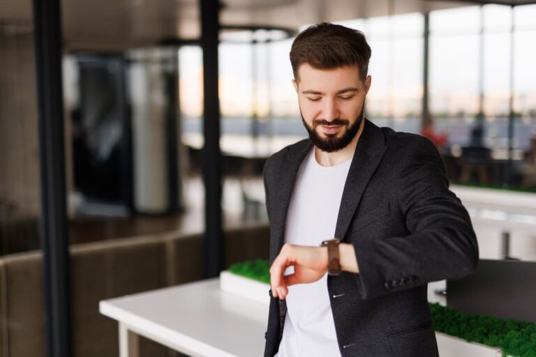 Business traveler checking his watch while preparing for an international flight at the airport