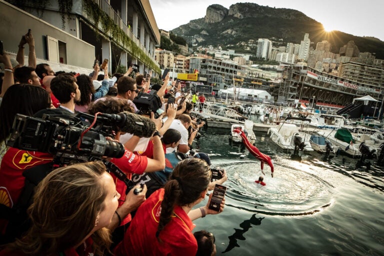 Charles Leclerc celebrating after winning the Monaco Grand Prix near the harbor in Monte Carlo