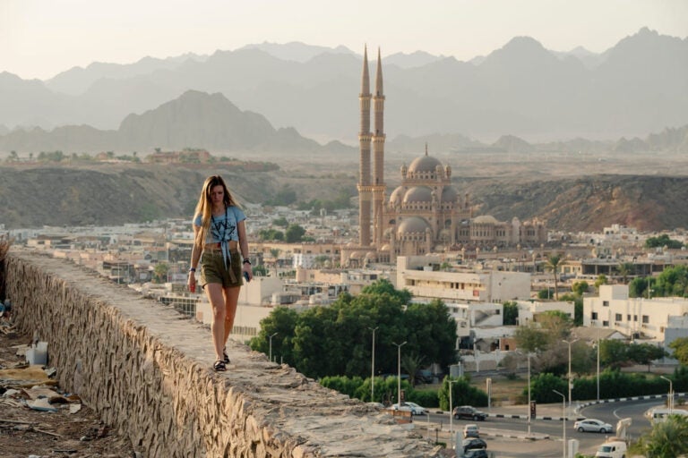 Female tourist walking near a mosque during Ramadan in a Muslim-majority country