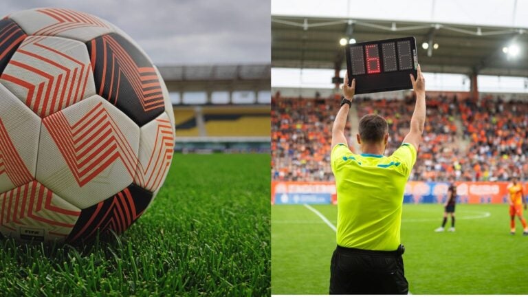 Football on a stadium pitch beside an official holding up an electronic substitution board.