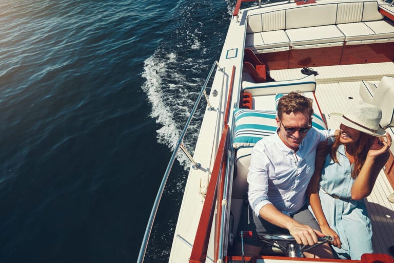 Couple enjoying a yacht during Monaco Grand Prix weekend with the harbor and race circuit nearby